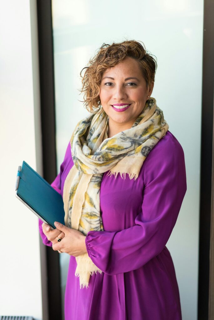 Woman Smiling and Holding Teal Book